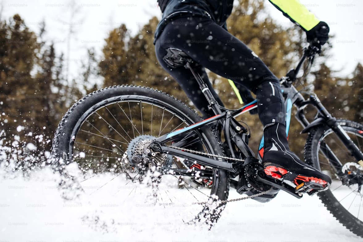 Cyclist riding through winter snow